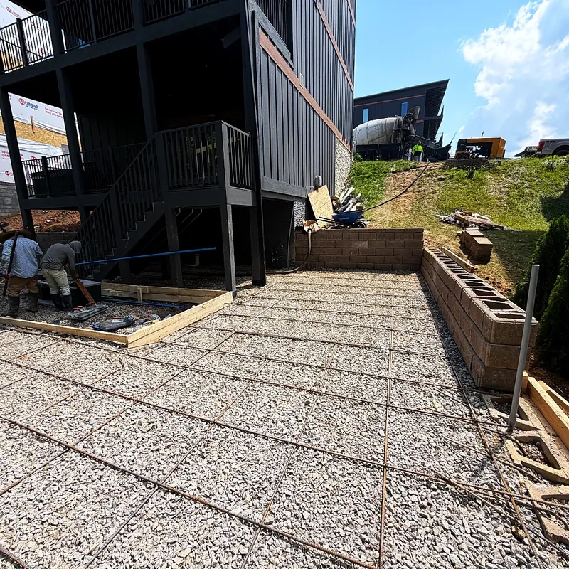 Reinforcing steel tied in a grid over a compacted stone base inside formed edges, before the pour