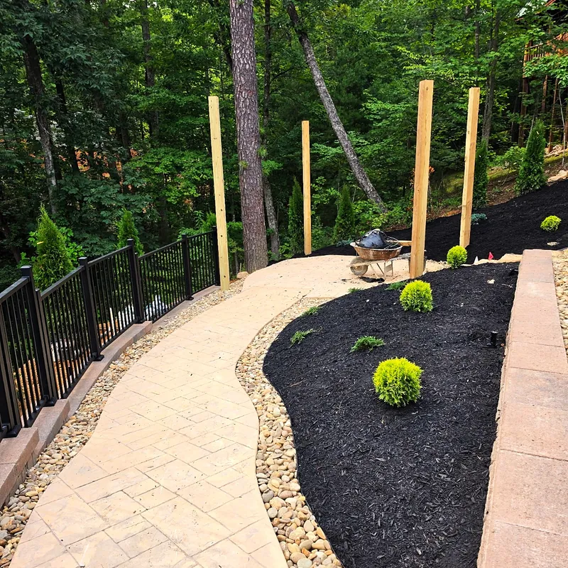 Stamped concrete walkway bordered by mulch beds
